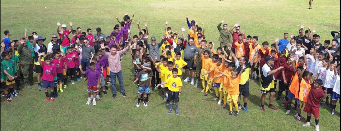 ELBFA players, coaches and community members celebrating together on a football field